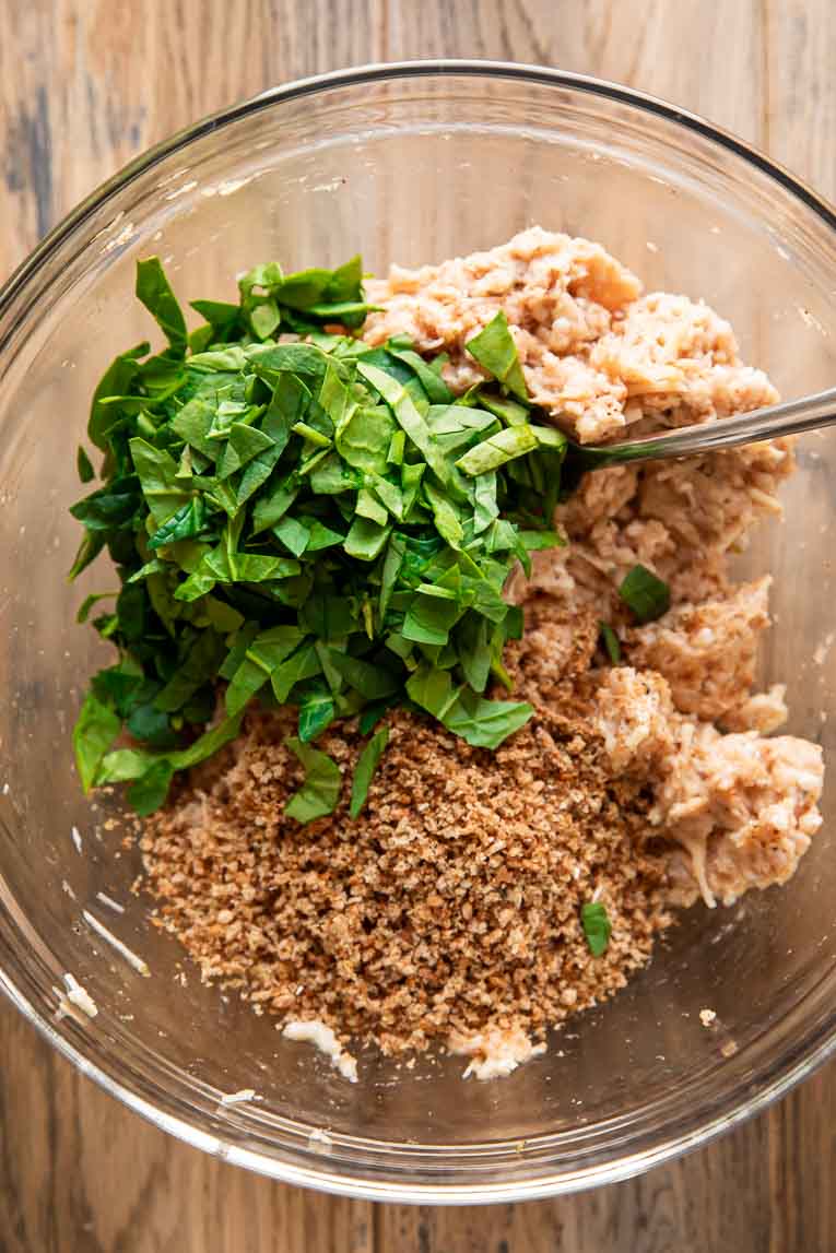 Bread crumbs and spinach mixed with ground chicken.
