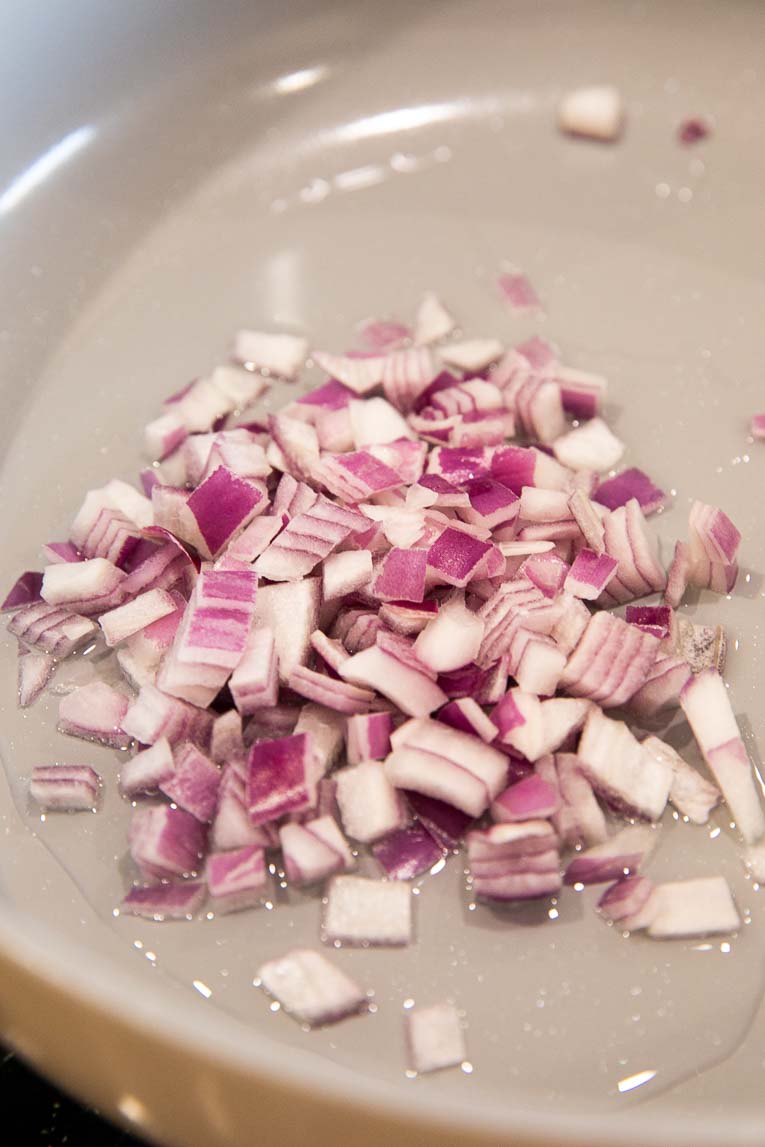 Onions being cooked in a pan.
