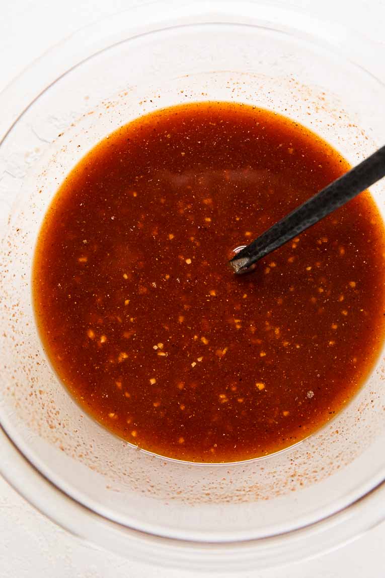 Buffalo sauce being mixed together in a glass bowl.