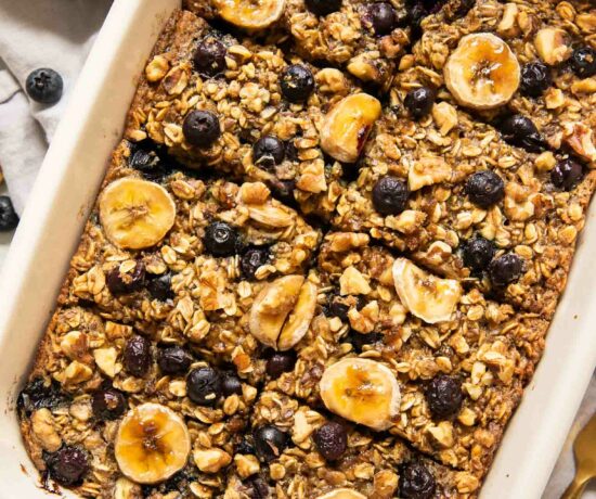 Blueberry banana baked oatmeal in a casserole dish topped with fresh fruit.