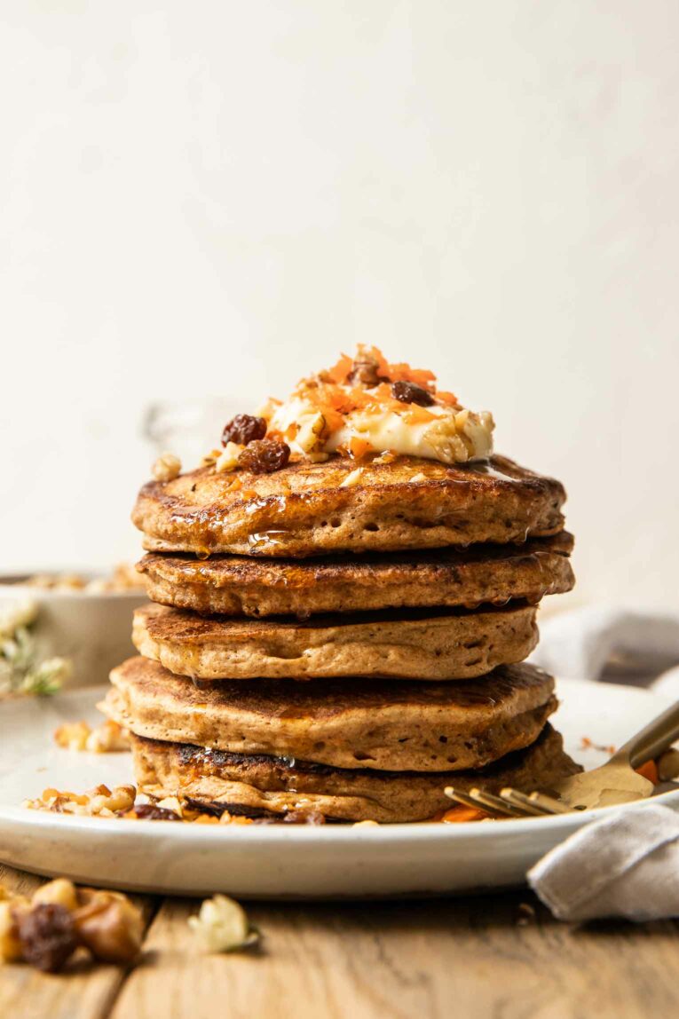 Carrot cake pancakes stacked with toppings.