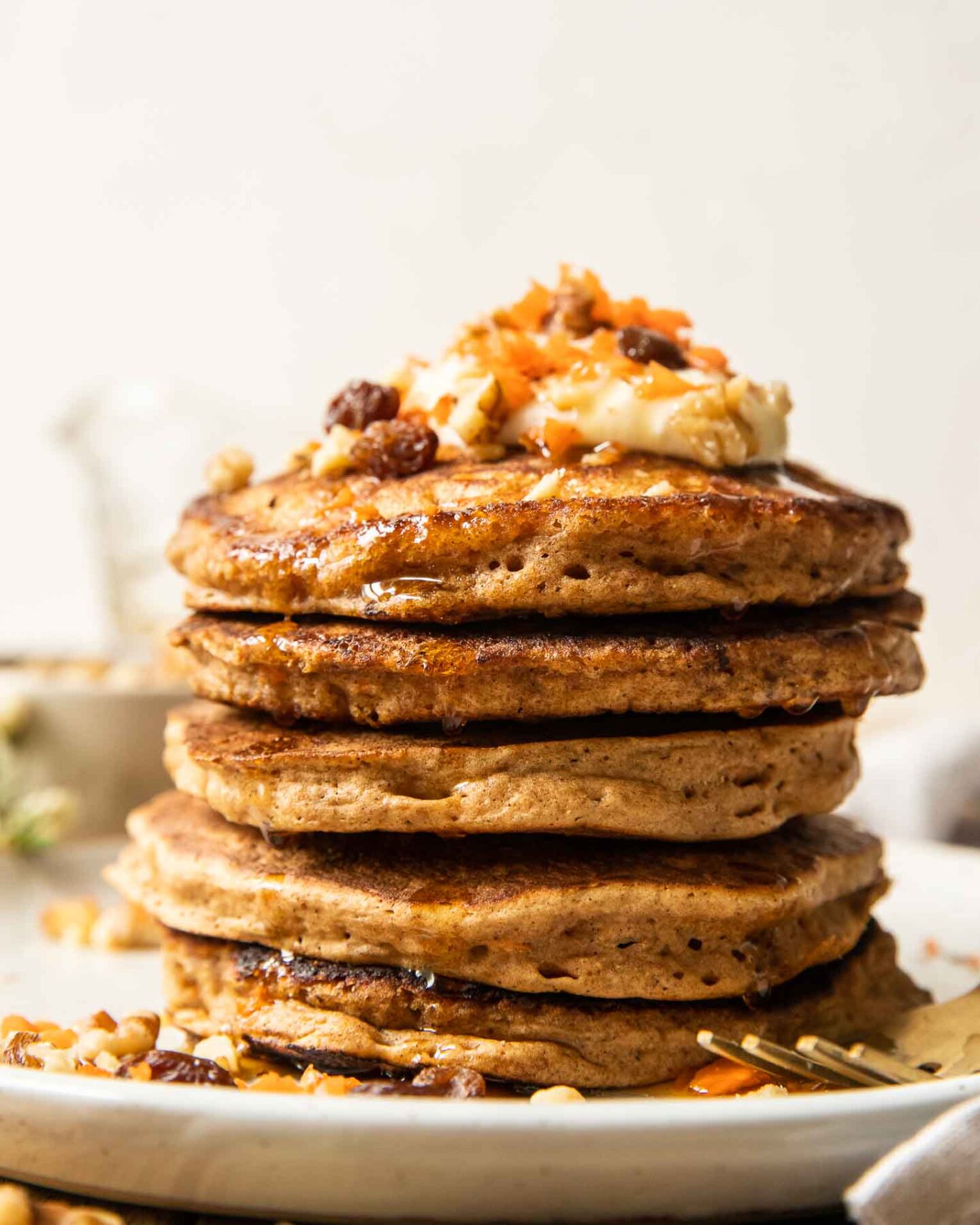 Walnuts and raisins on a stack of carrot cake pancakes.