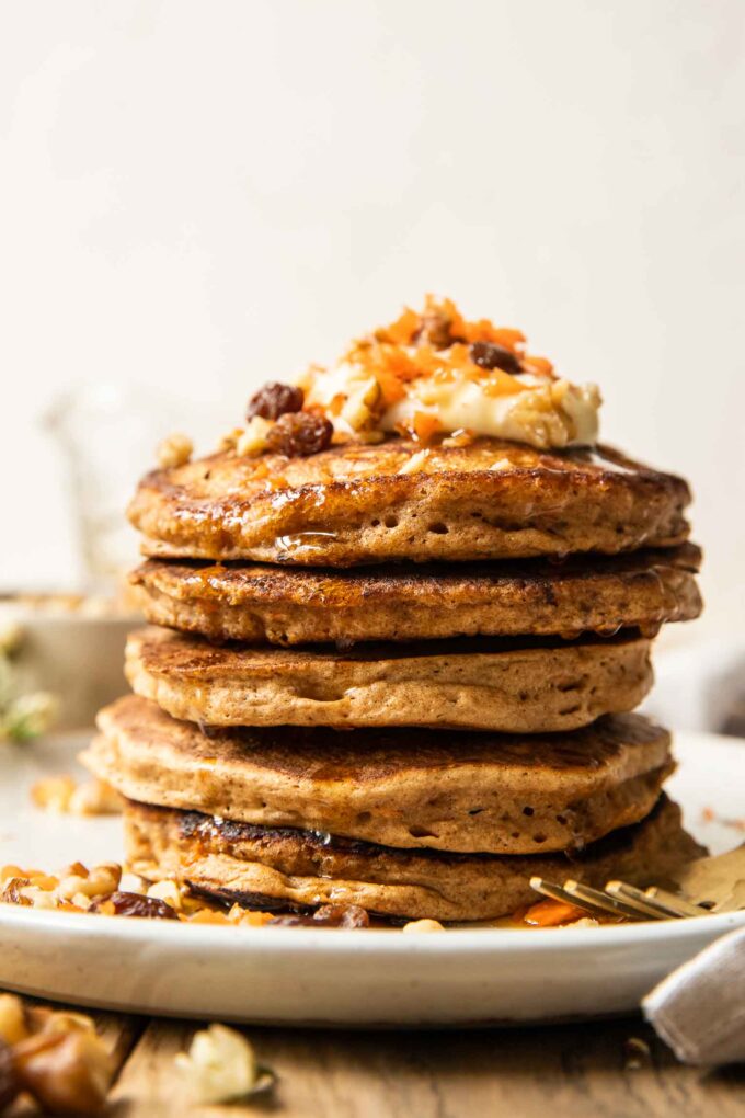 Walnuts and raisins on a stack of carrot cake pancakes.