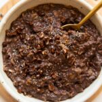 Top photo of Chocolate Protein Oats in a bowl with a spoon.