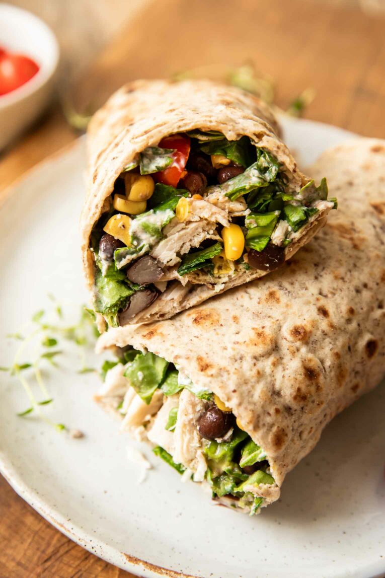Angled photo of ranch chicken wraps stacked on top of each other.