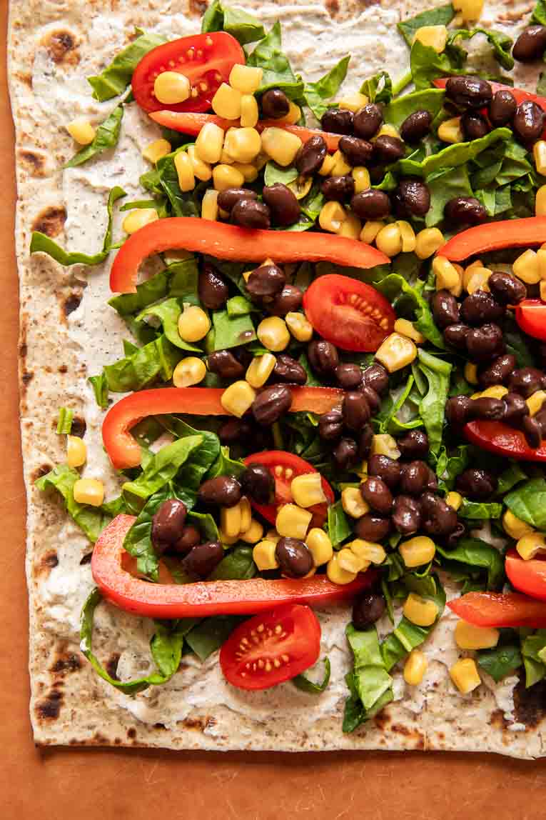Wrap tortilla topped with ranch, beans, corn, and peppers.