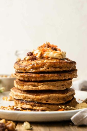 Carrot cake pancakes stacked with toppings.
