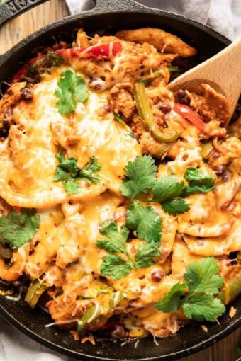 Top shot photo of chicken fajita casserole with a spoon.