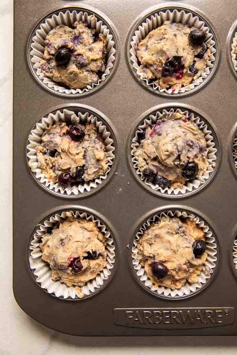 Raw blueberry banana muffins in a tray.