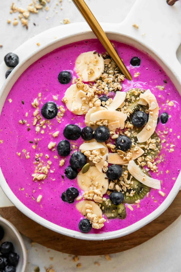 Dragon fruit smoothie bowl topped with banana, blueberries, and granola.