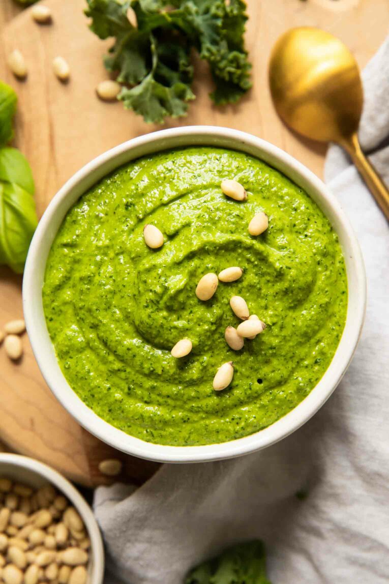 Kale pesto in a bowl with pine nuts.