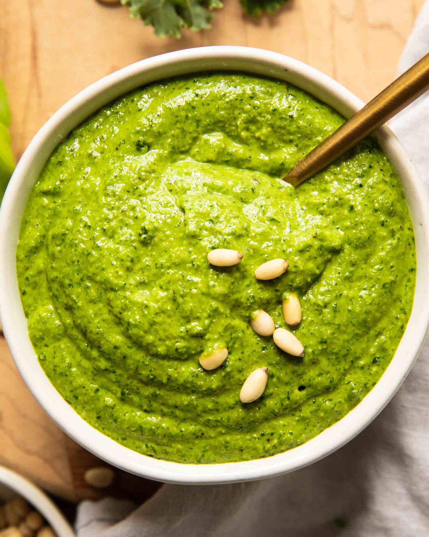 Kale pesto that's creamy and delicious in a bowl with a spoon.