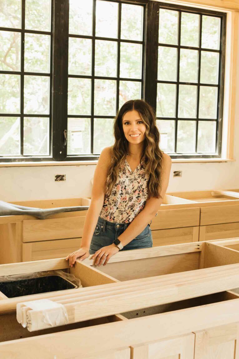 Woman standing in unfinished kitchen.