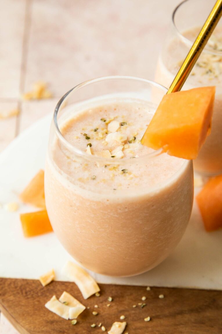 Angled photo of cantaloupe smoothie with toppings.