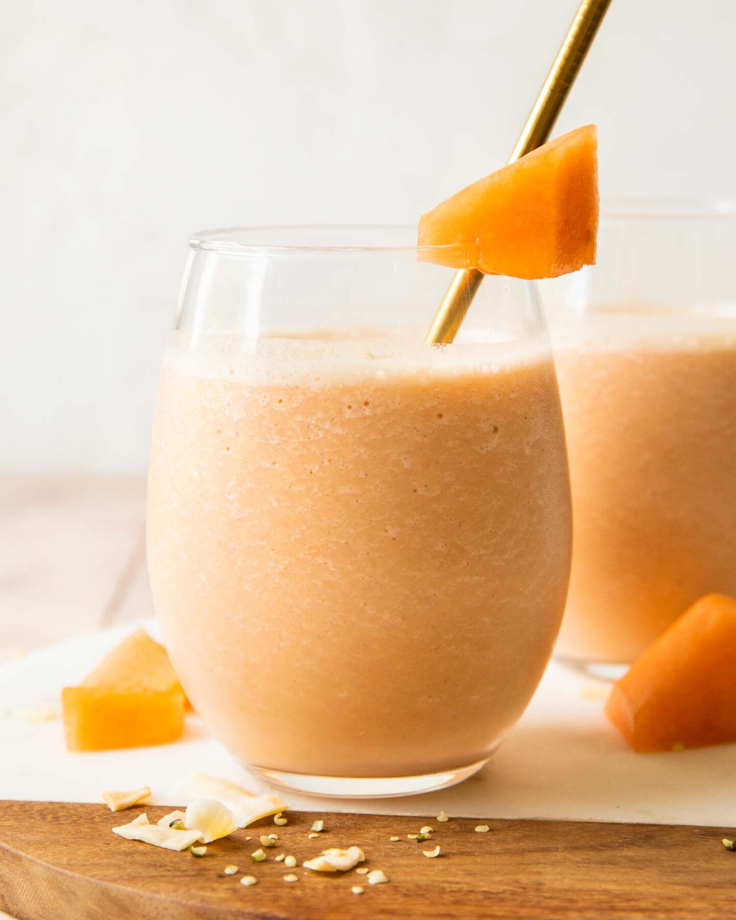 Cantaloupe Smoothie recipe in a glass with a straw.