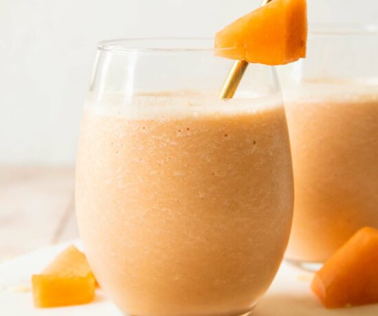 Cantaloupe Smoothie recipe in a glass with a straw.