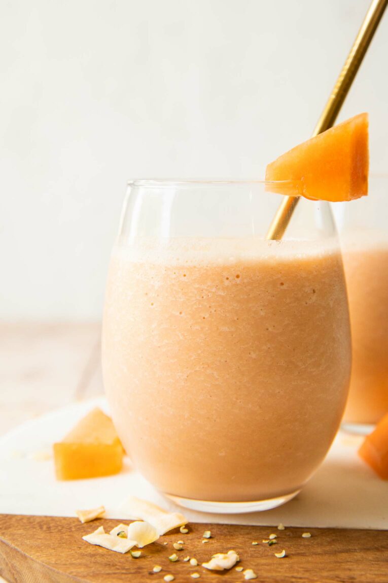 Close up of Cantaloupe smoothies in a glass with a straw.