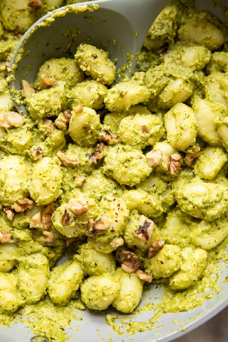 Pesto gnocchi being cooked in a pan.
