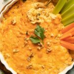 Healthy buffalo chicken dip recipe with celery, carrots, and parsley.