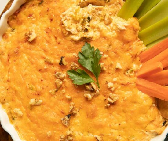 Healthy buffalo chicken dip recipe with celery, carrots, and parsley.