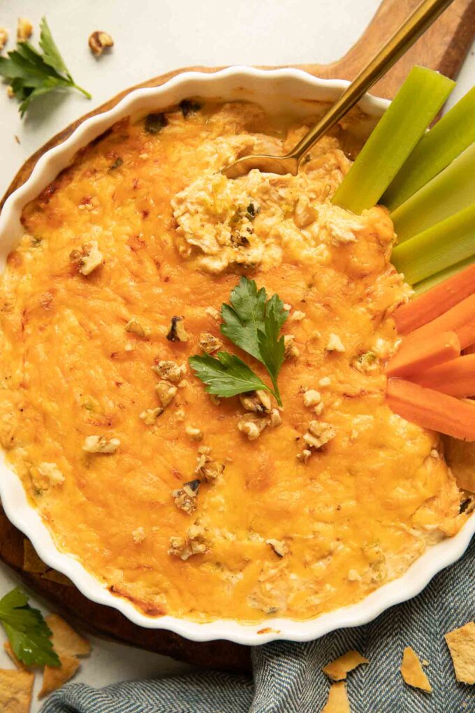 Healthy buffalo chicken dip recipe with celery, carrots, and parsley.