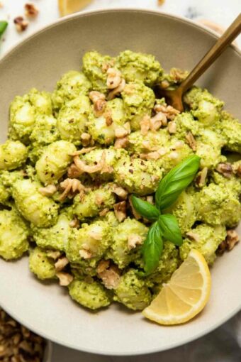 Pesto Gnocchi in a bowl with lemon, kale, and basil.