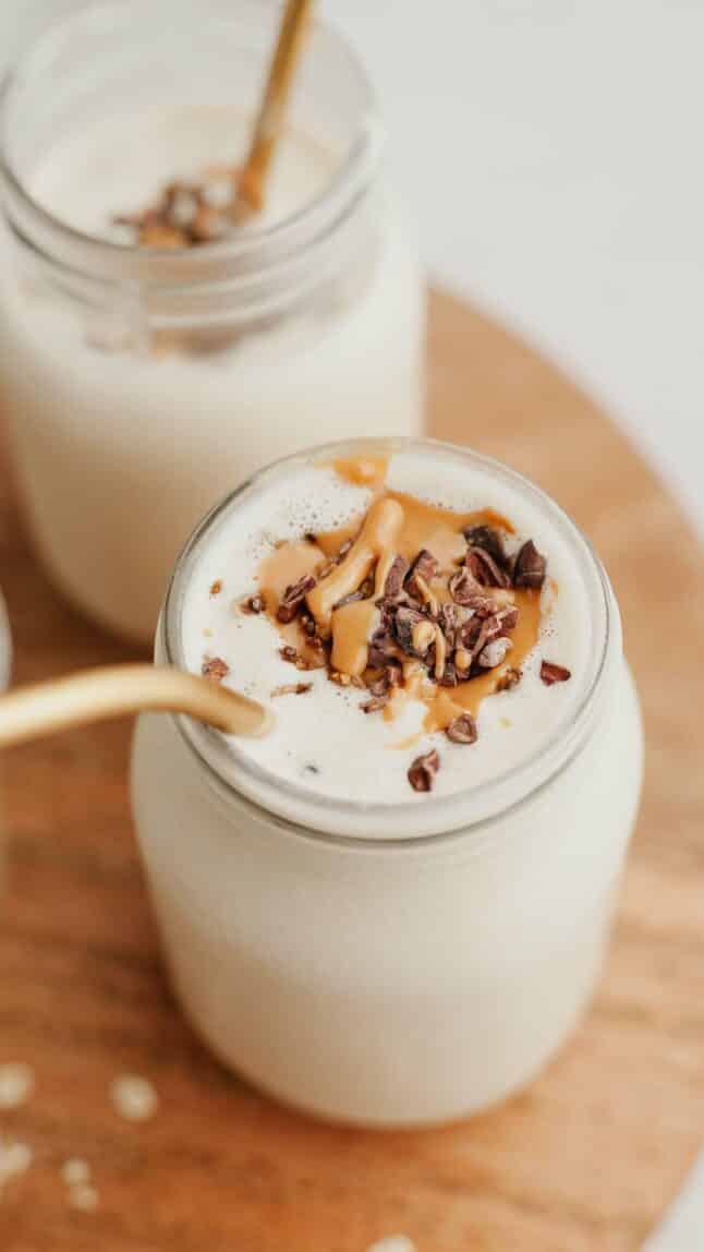 Angled photo of peanut butter oatmeal smoothie in a mason jar.