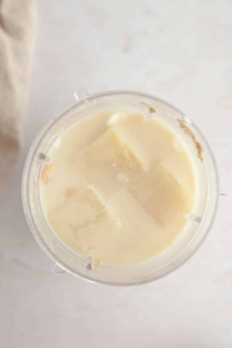 Smoothie being blended in a cup with almond milk ice cubes.