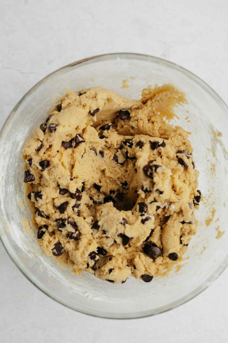 Chocolate chips added to vegan cookie dough in a bowl.