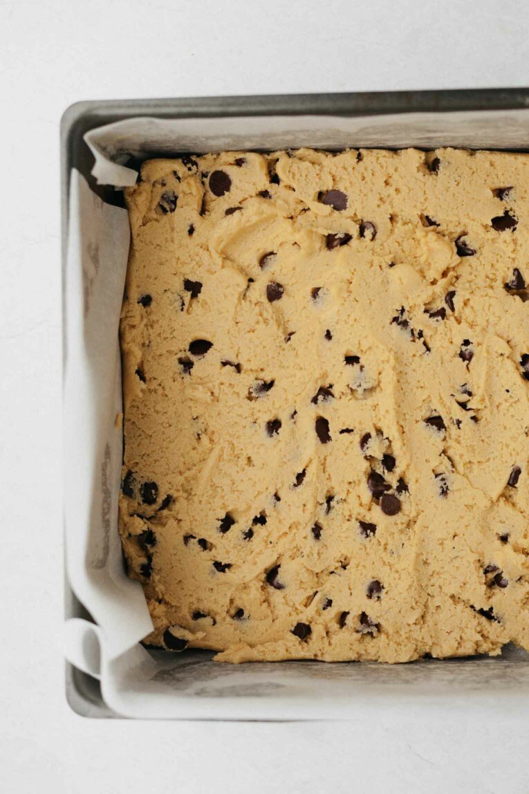 Vegan cookie dough poured into a baking pan.