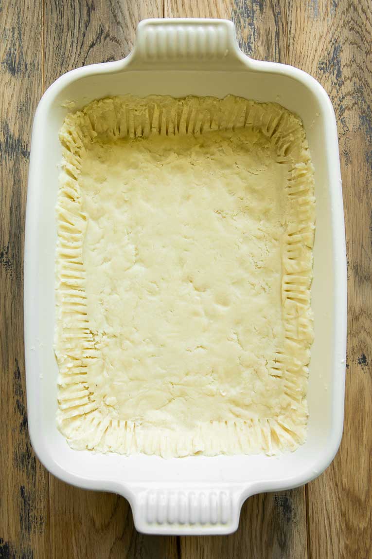 Chicken pot pie dough pressed into a baking dish.