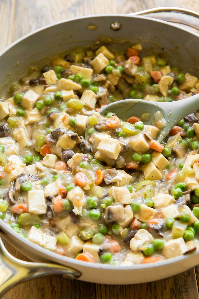 Chicken pot pie filling being cooked in a pan.