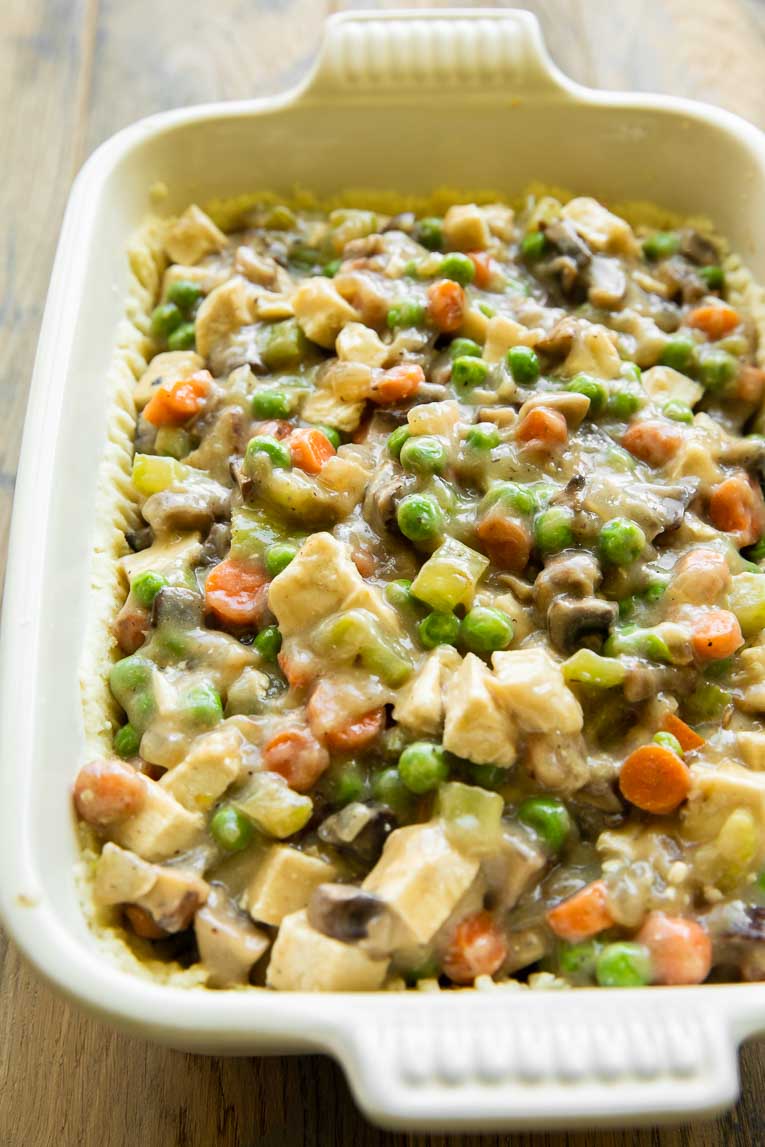 Chicken pot pie filling poured into a gluten-free pie crust.
