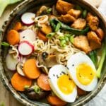 Spicy chicken ramen in a large bowl on a wood background.