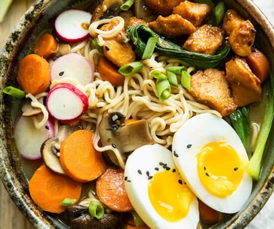 Spicy chicken ramen in a large bowl on a wood background.