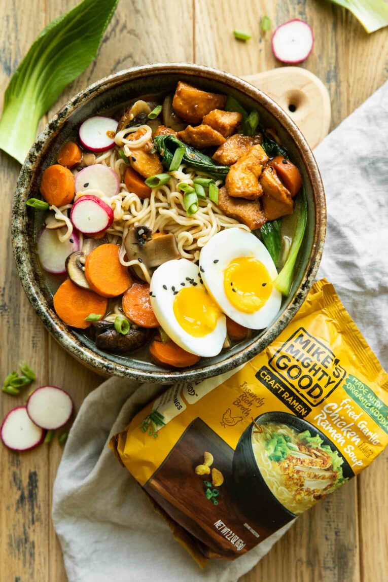 Bowl of spicy chicken ramen next to Mike's Mighty Good ramen package.