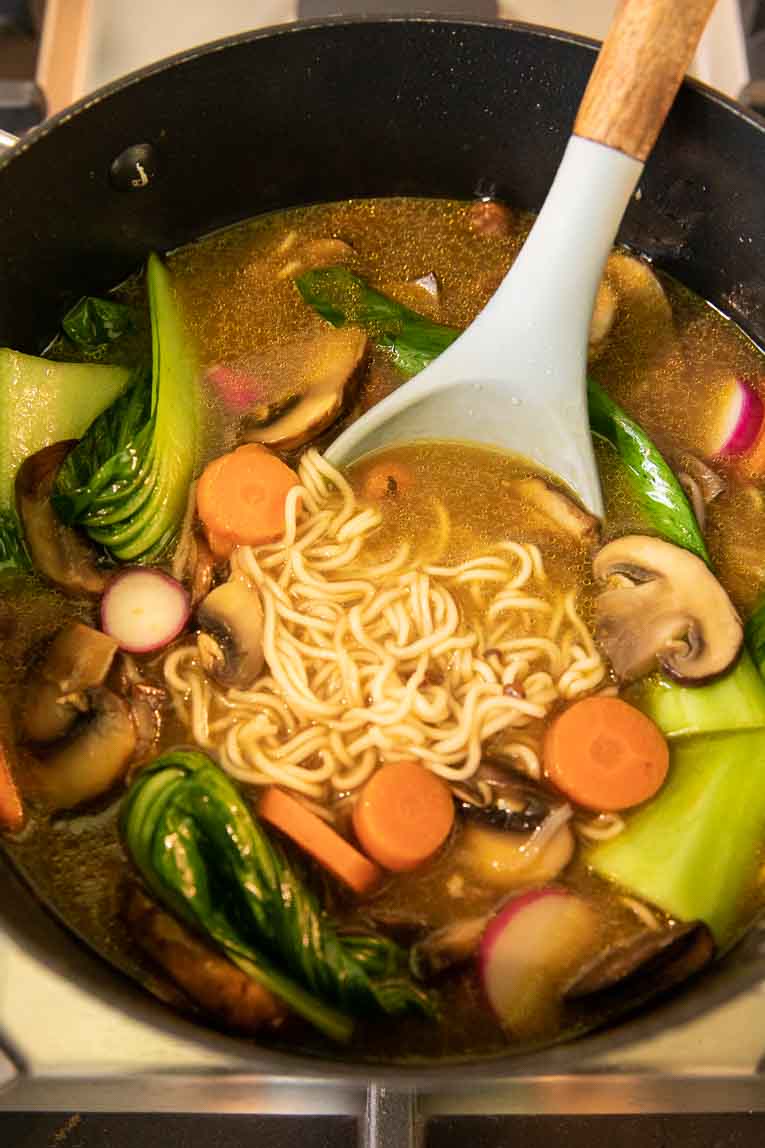 Spicy chicken ramen being cooked on the stovetop.