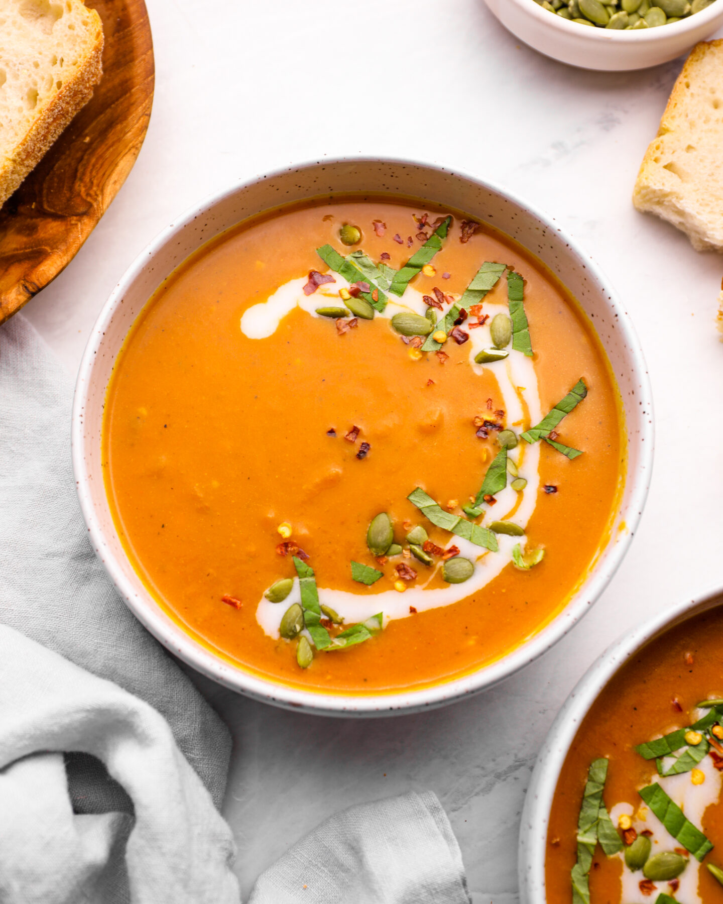Pumpkin curry soup with chopped basil and pepitas.