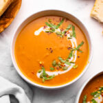 Pumpkin curry soup with chopped basil and pepitas.