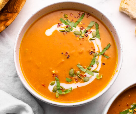 Pumpkin curry soup with chopped basil and pepitas.