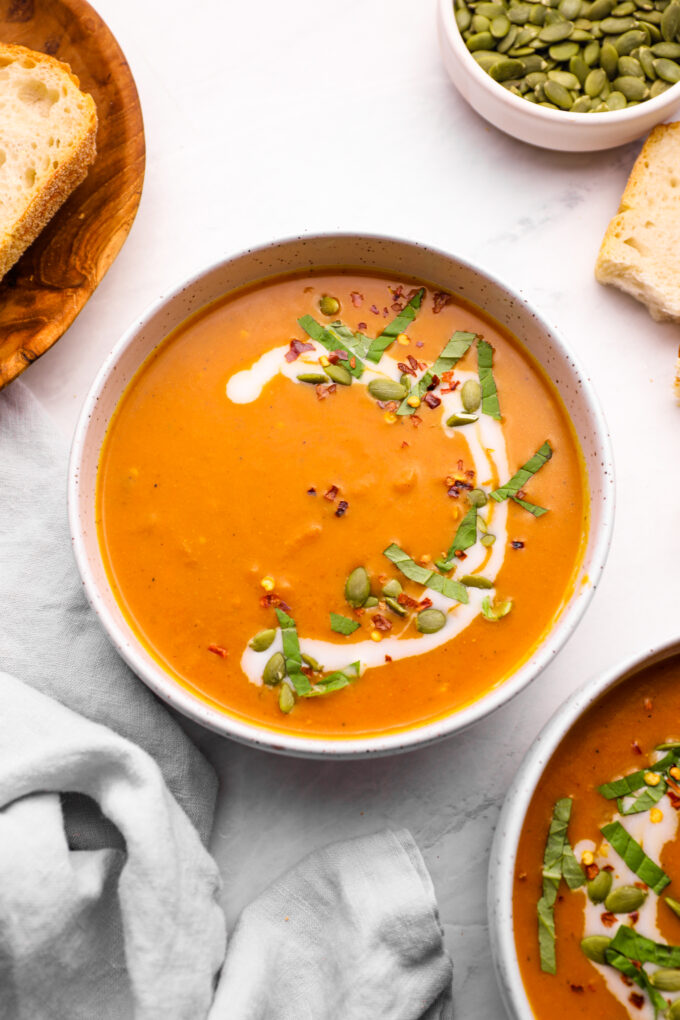 Pumpkin curry soup with chopped basil and pepitas.