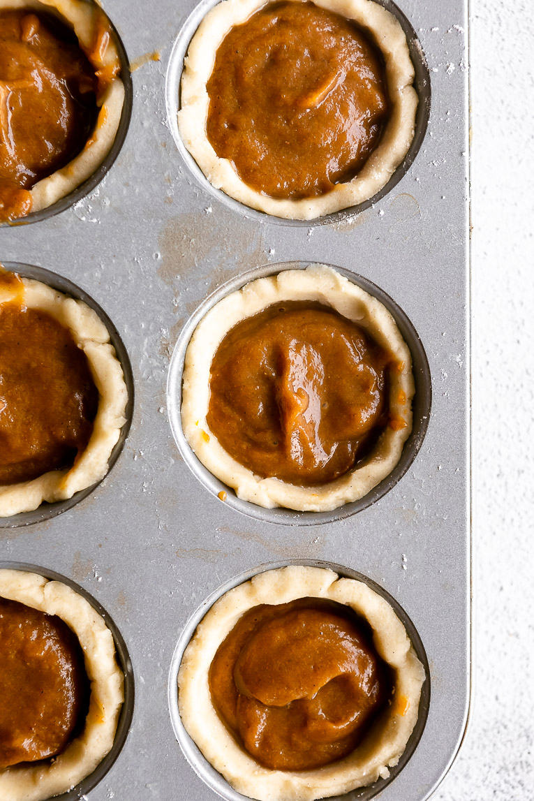Mini pumpkin pies in a cupcake tray.