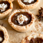 Mini pumpkin pies with whipped cream on top.