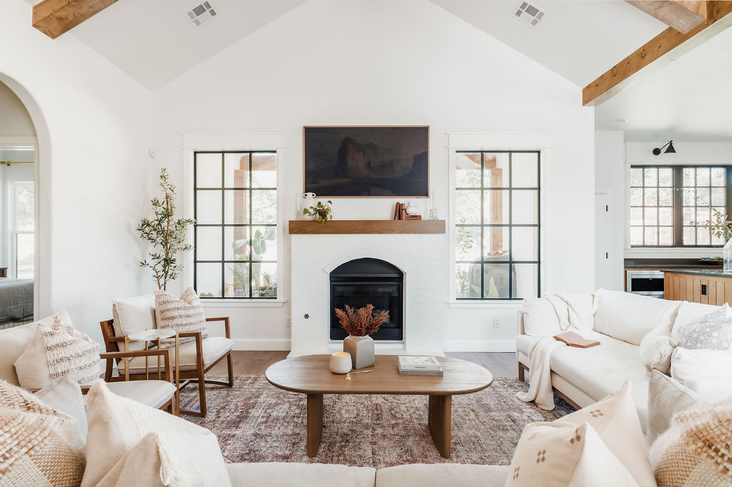 Grid windows and arched brick fireplace with TV in living room.