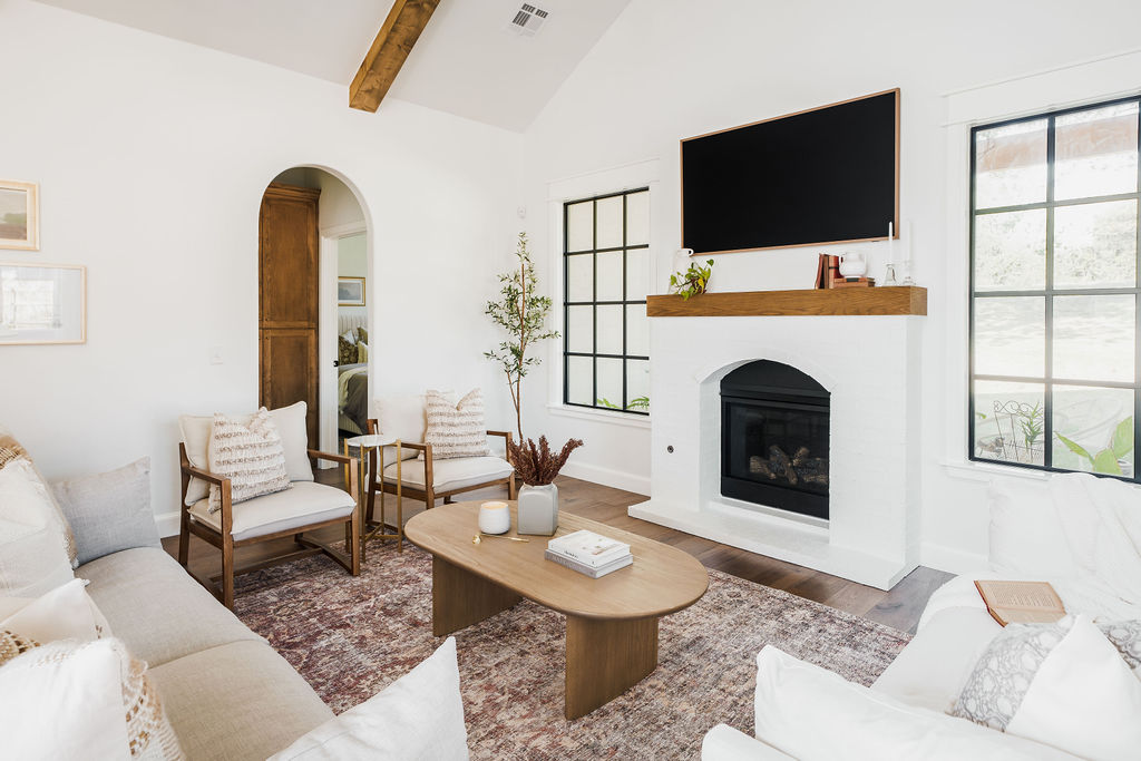 Living room with arched doorways and arched fireplace.