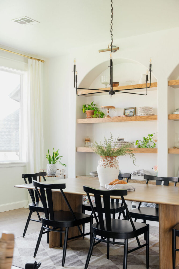 Styled dining room with arched built-in shelves.