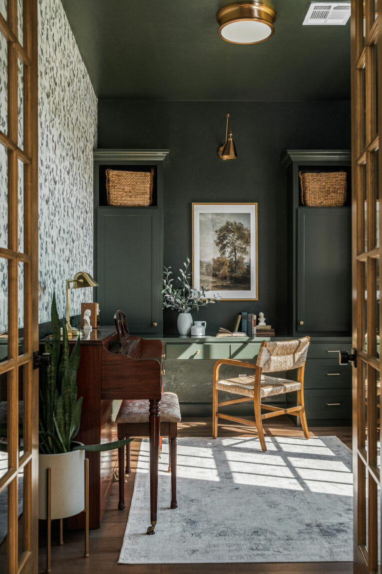 Dark green office with wallpaper. Gold and wood accents.