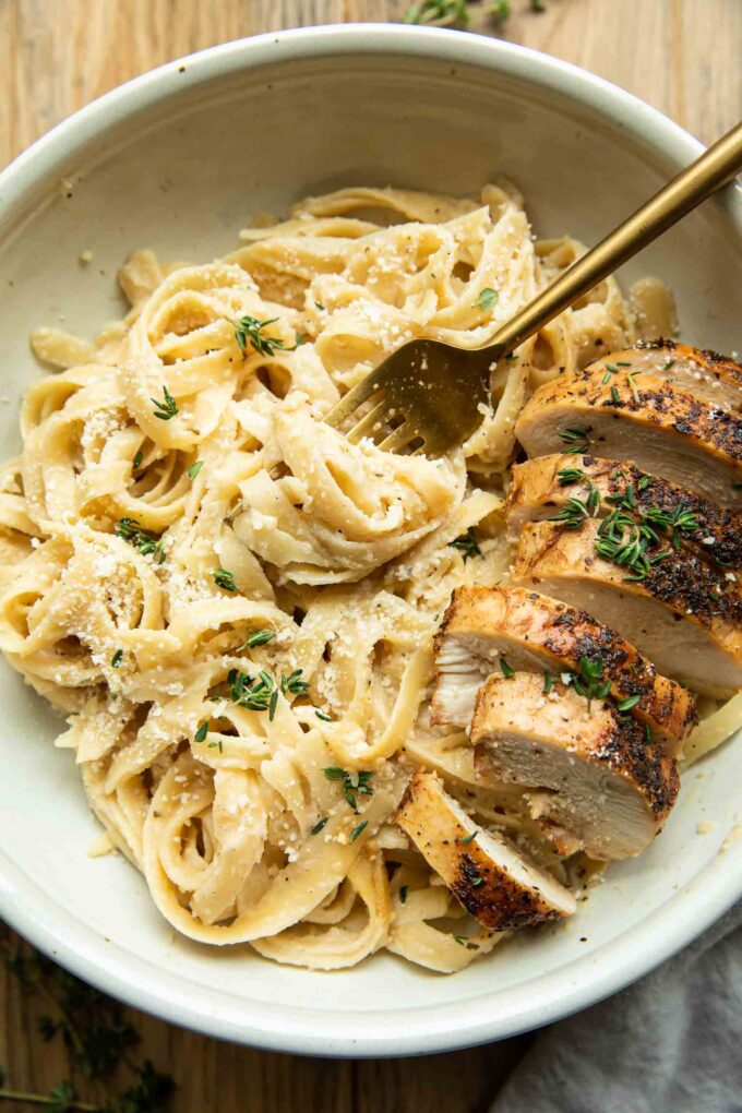 Healthy Chicken Alfredo with Cauliflower Sauce in a bowl with a fork.