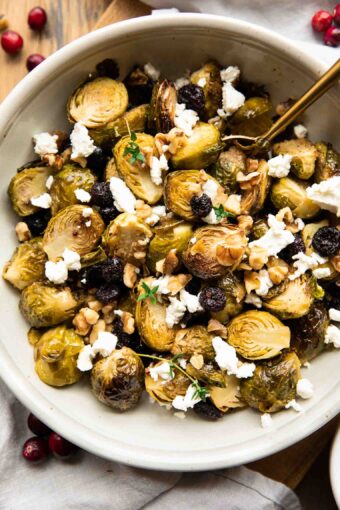 Roasted Brussels Sprouts with Goat Cheese in a bowl with a spoon.