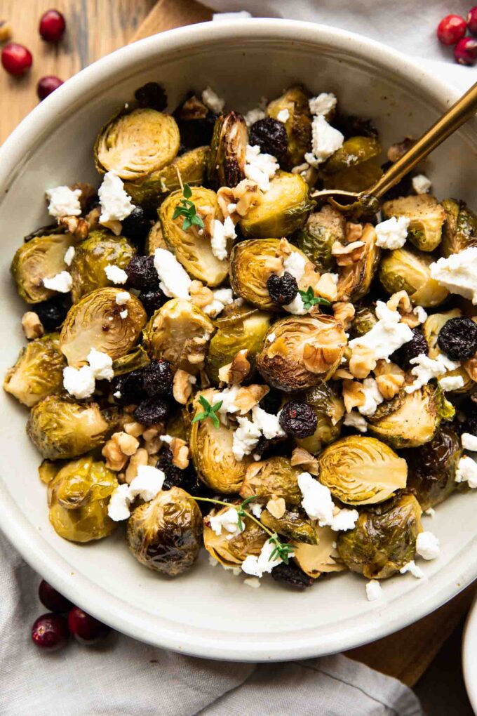 Roasted Brussels Sprouts with Goat Cheese in a bowl with a spoon.